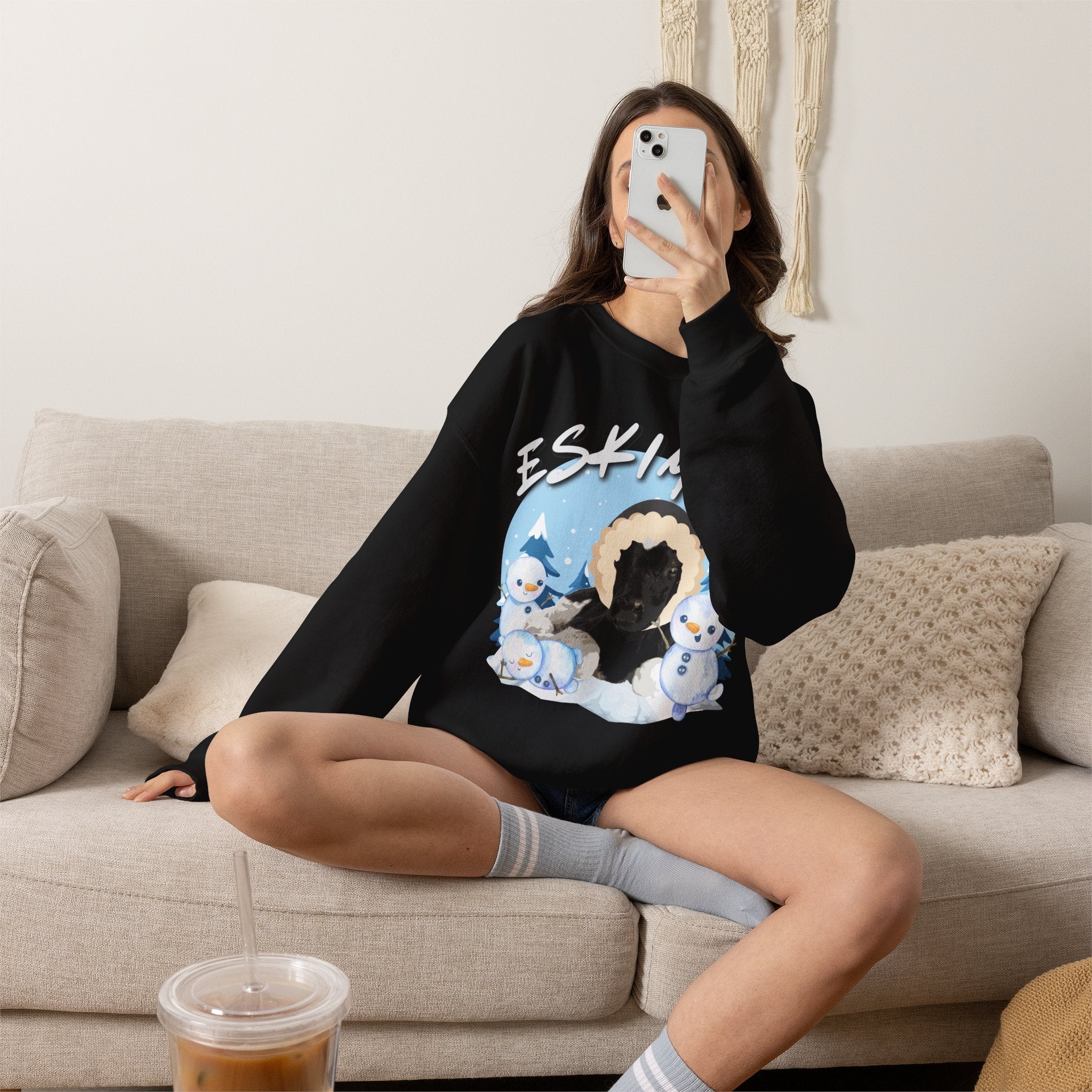 Dark heather sweatshirt with EskiMOO pun design showing a calf snowman in a snowy winter scene — front view