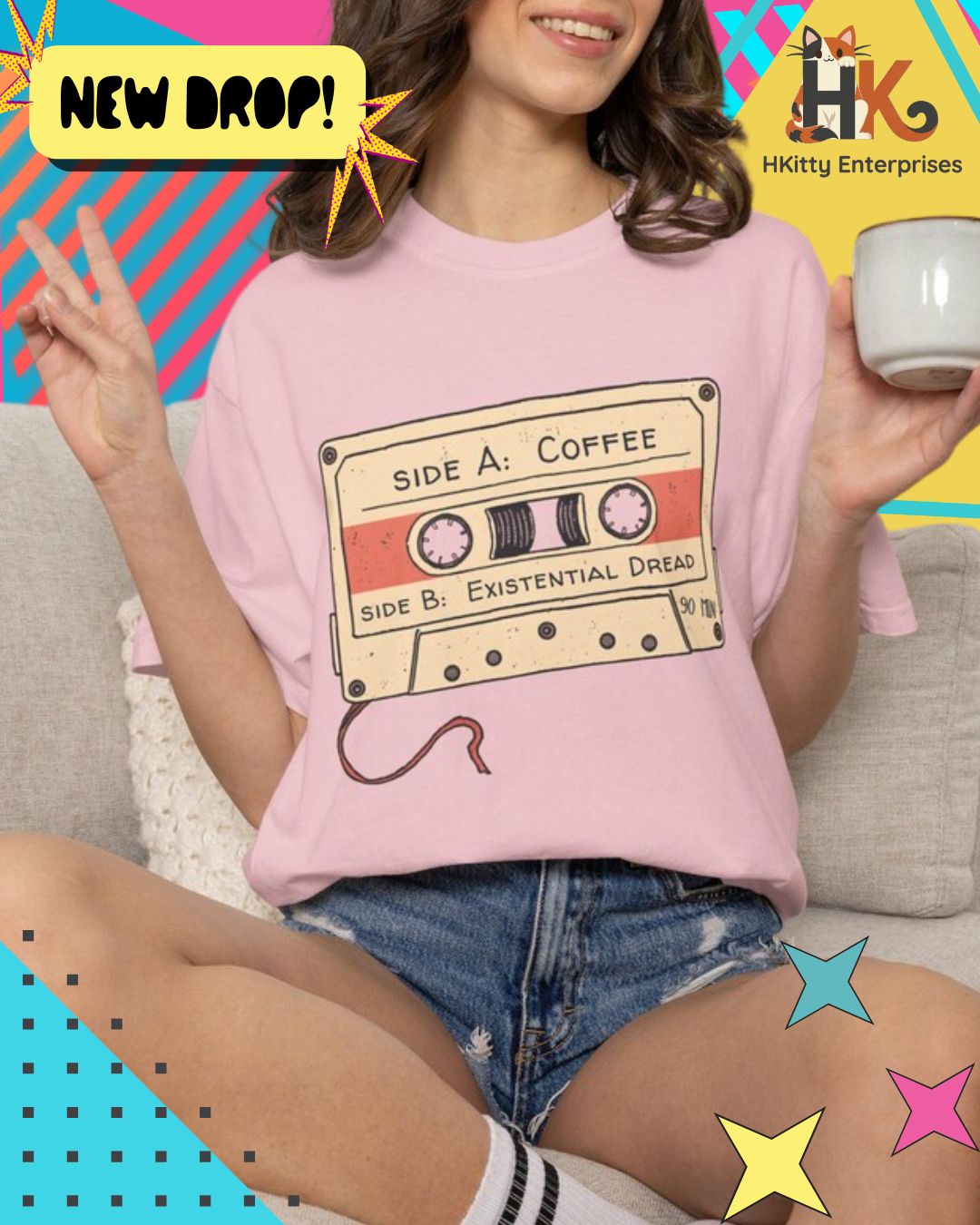 A woman wearing a light pink t-shirt with a retro cassette tape graphic that reads 'SIDE A: COFFEE' and 'SIDE B: EXISTENTIAL DREAM'. She is sitting on a couch holding a mug, with a colorful graphic background and 'HKitty Enterprises' logo.